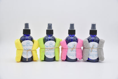 Four blue yoga mat cleaner bottles with colorful cleaning cloths