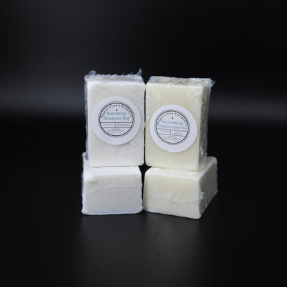 Four wrapped shampoo and conditioner bars stacked in pairs