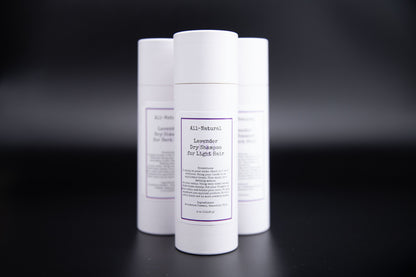 Three Lavender dry shampoo containers arranged on a dark background