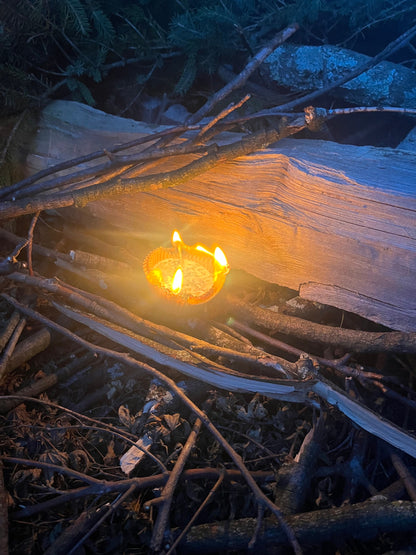 Lit soy wax fire starter at the base of stacked firewood
