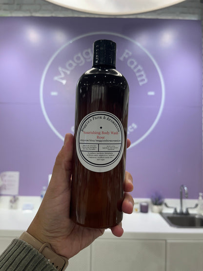 Hand holding a Rose body wash bottle inside the shop