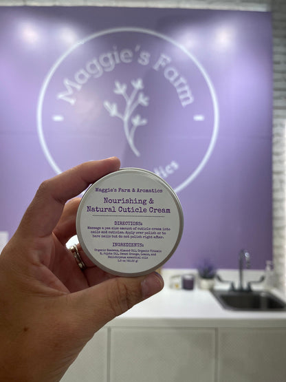 Hand holding a silver cuticle cream tin inside the shop