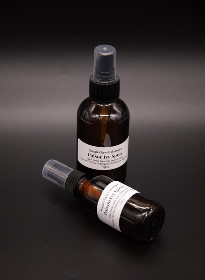 Two amber outdoor skin spray bottles arranged on a dark surface