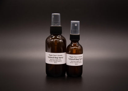Large and small outdoor body spray bottles on a dark surface