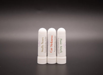 Three white pocket aromatic inhalers on a dark surface