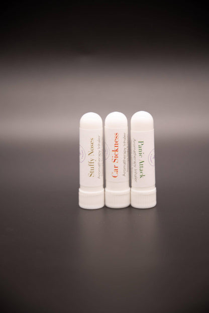Three white pocket aromatic inhalers viewed from a distance