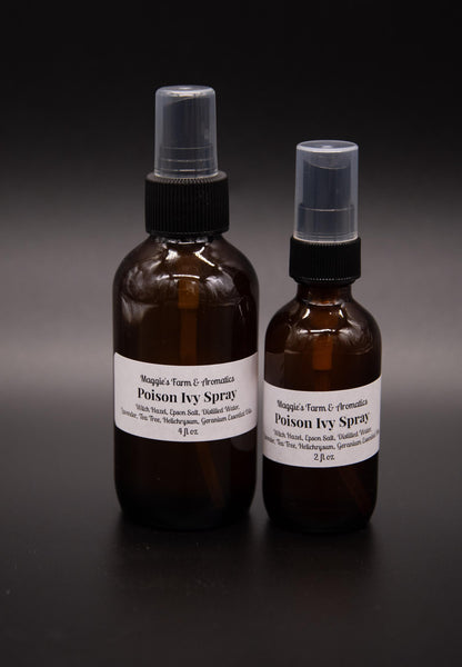 Large and small amber outdoor skin spray bottles on a dark surface