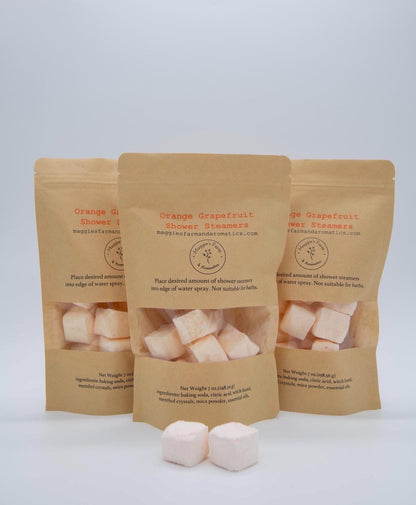 Three Orange Grapefruit Shower Steamers packages with peach-colored cubes